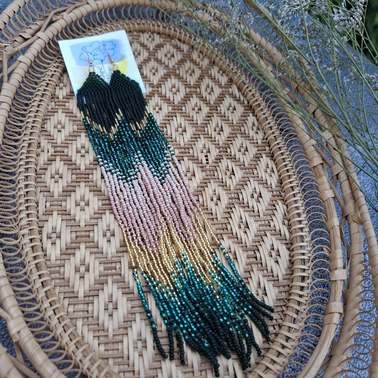 Long boho beaded fringe earrings in turquoise and gold held in hand