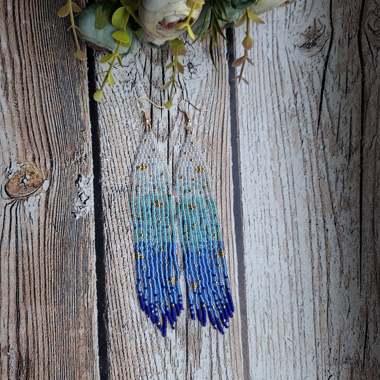 Handmade jewelry piece with soft blue gradient fringe