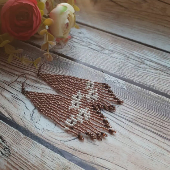 Close-up of the detailed beadwork in brown and ivory tones.